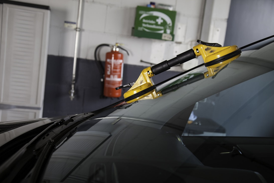 Auto glass tool placed on a windshield prepped for an auto glass service