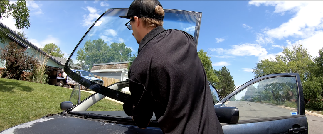 Auto glass technician performing a windshield replacement service