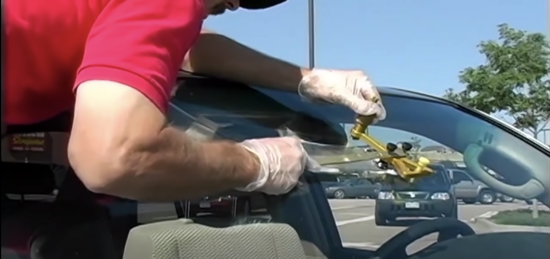 Auto glass technician getting a windshield repair done